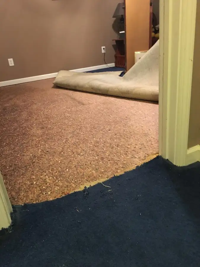 Carpet pad removal revealing water damage during Water Mitigation Services in Sallisaw